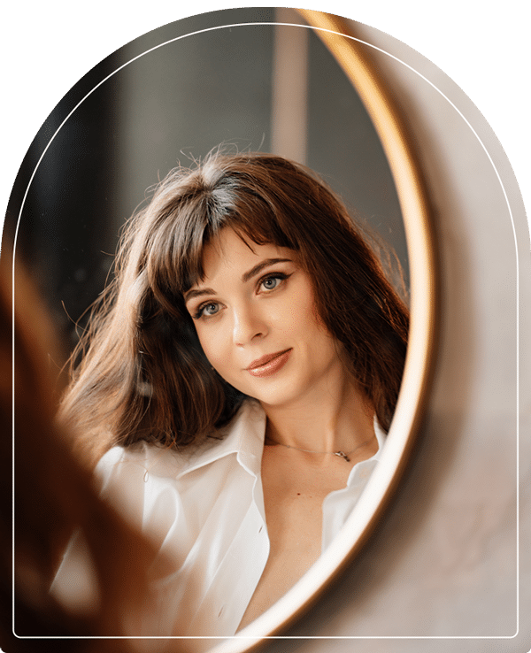 a woman standing in front of a mirror posing for the camera